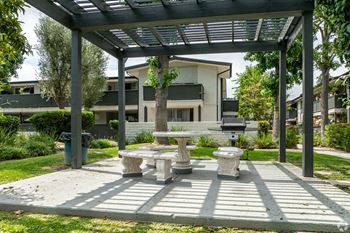 A patio with a table and chairs under a roof.